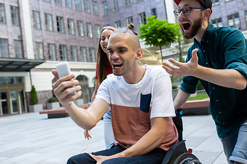 Image showing Group of friends taking a stroll on city\'s street in summer day