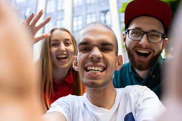 Image showing Group of friends taking a stroll on city\'s street in summer day