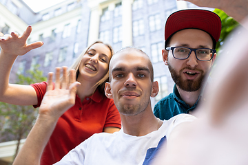 Image showing Group of friends taking a stroll on city\'s street in summer day