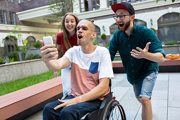 Image showing Group of friends taking a stroll on city\'s street in summer day