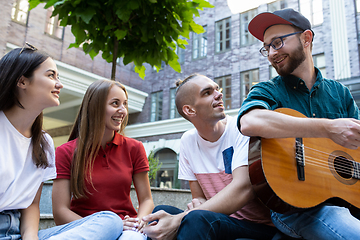 Image showing Group of friends taking a stroll on city\'s street in summer day