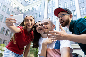 Image showing Group of friends taking a stroll on city\'s street in summer day