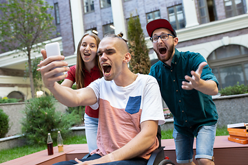 Image showing Group of friends taking a stroll on city\'s street in summer day