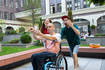 Image showing Group of friends taking a stroll on city\'s street in summer day