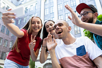 Image showing Group of friends taking a stroll on city\'s street in summer day