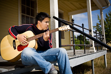 Image showing Asian playing guitar