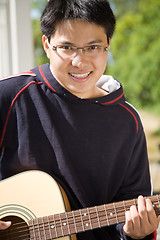 Image showing Young asian guitar player