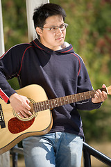 Image showing Young asian guitar player