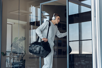 Image showing Sports man against modern glassed building, airport in megapolis