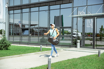 Image showing Sports man against modern glassed building, airport in megapolis