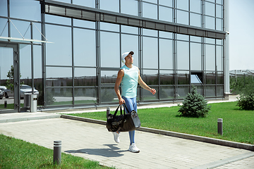 Image showing Sports man against modern glassed building, airport in megapolis