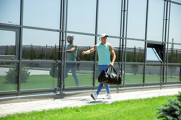 Image showing Sports man against modern glassed building, airport in megapolis