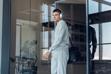 Image showing Sports man against modern glassed building, airport in megapolis