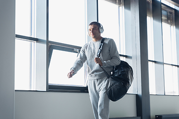 Image showing Sports man against modern glassed building, airport in megapolis