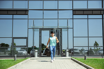 Image showing Sports man against modern glassed building, airport in megapolis