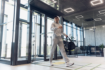 Image showing Sports man against modern glassed building, airport in megapolis