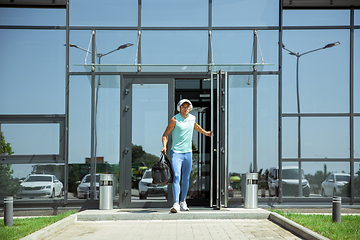 Image showing Sports man against modern glassed building, airport in megapolis