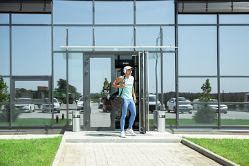 Image showing Sports man against modern glassed building, airport in megapolis