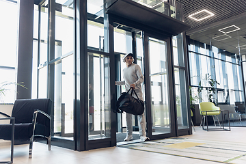 Image showing Sports man against modern glassed building, airport in megapolis