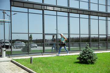 Image showing Sports man against modern glassed building, airport in megapolis