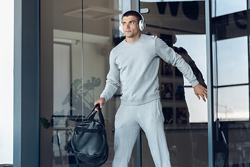 Image showing Sports man against modern glassed building, airport in megapolis