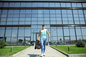 Image showing Sports man against modern glassed building, airport in megapolis