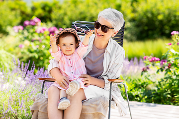 Image showing happy grandmother and baby granddaughter at garden