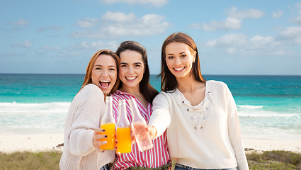 Image showing young women toasting non alcoholic drinks on beach