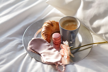 Image showing croissant, coffee and eye sleeping mask in bed