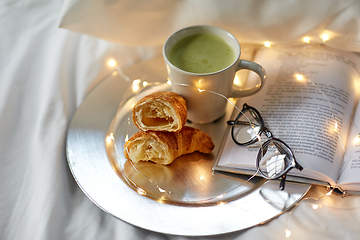 Image showing croissants, matcha tea, book and glasses in bed