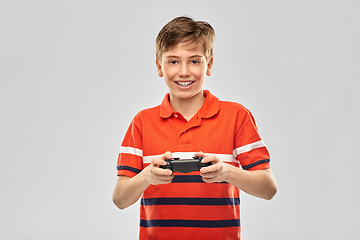 Image showing smiling boy with gamepad playing video game