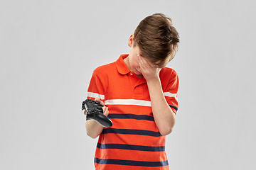 Image showing unhappy boy with gamepad playing video game