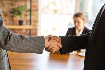 Image showing Close up of businessmen shaking hands in conference room