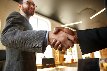 Image showing Close up of businessmen shaking hands in conference room