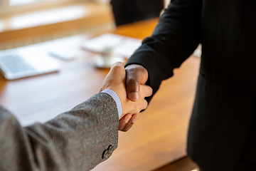 Image showing Close up of businessmen shaking hands in conference room