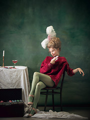 Image showing Young woman as Marie Antoinette on dark background. Retro style, comparison of eras concept.