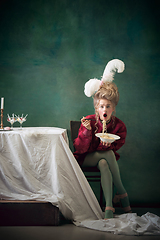 Image showing Young woman as Marie Antoinette on dark background. Retro style, comparison of eras concept.