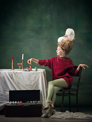 Image showing Young woman as Marie Antoinette on dark background. Retro style, comparison of eras concept.