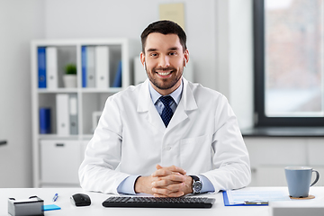 Image showing doctor in earphones having video call at clinic