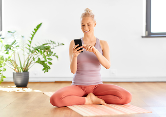 Image showing woman with smartphone at home or yoga studio