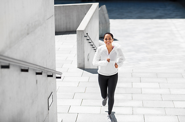 Image showing african american woman running upstairs outdoors