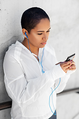 Image showing african american woman with earphones and phone