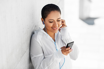 Image showing african american woman with earphones and phone