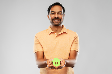 Image showing smiling indian man holding green house icon