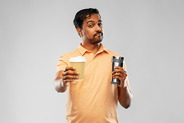 Image showing man comparing thermo cup or tumbler and coffee cup