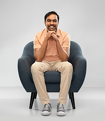 Image showing happy smiling young indian man sitting in chair