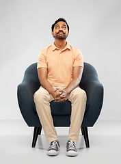 Image showing happy smiling young indian man sitting in chair