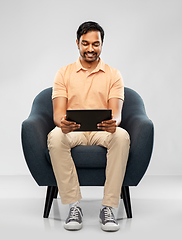 Image showing happy indian man with tablet pc computer in chair