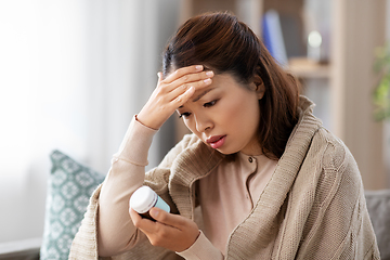 Image showing sick asian woman with painkiller medicine at home