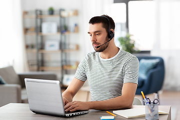 Image showing man with headset and laptop working at home